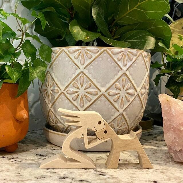 Holzskulptur von Mann und Hund